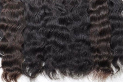 Close-up of curly black human hair extensions on a white background