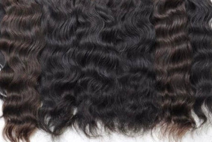 Close-up of curly black human hair extensions on a white background