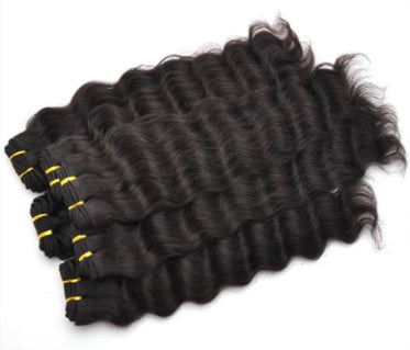Stack of black wavy human  hair extensions with yellow ties on a white background